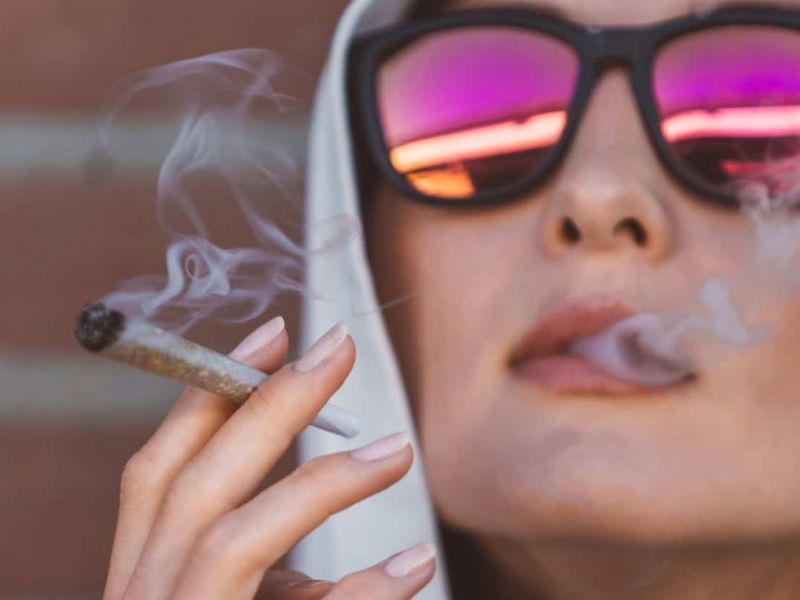 Young woman smoking a preroll to represent a blog about dispensary with delivery near me in pahrump